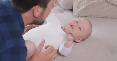 Close up of the baby lying on its back on the couch, smiling and happy, looking Stock Footage 140174668