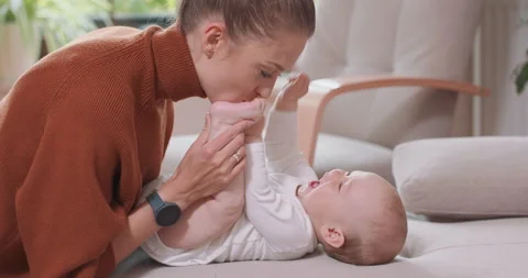 Close up of the baby lying on its back on the couch, smiling and happy, uprising 库存影片 140177115
