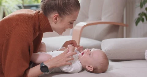 Close up of the baby lying on its back on the couch, smiling and happy, uprising Видео 140177540