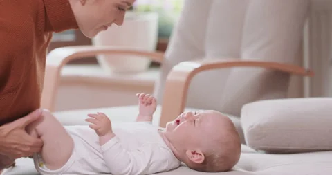 Close up of the baby lying on its back on the couch, smiling and happy, looking 库存影片 140177791