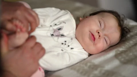 Close up of a baby lying on a soft surface, looking calm and curious while doing Stock Footage 335245732
