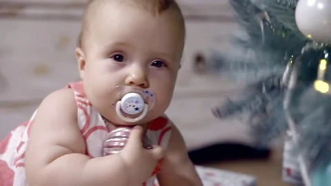 Close-up. a baby with a pacifier in his mouth shoots from the branches of a Stock Footage 82223853