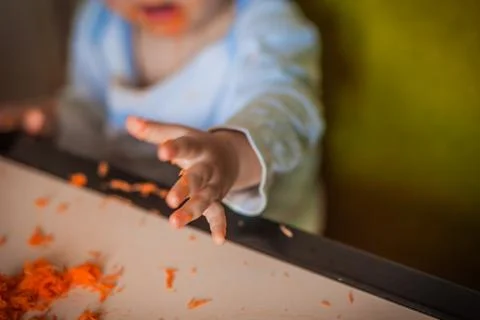 Close - up of the baby while eating with his bare hands Stock Photos