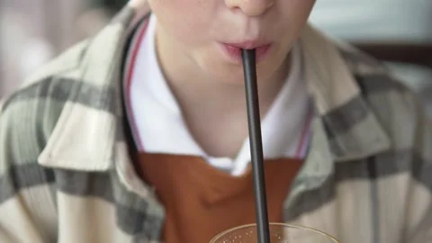 Close-up, the baby's face with a plastic straw in his mouth Stock Footage 224715292