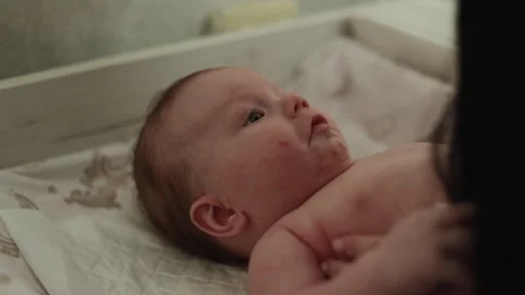 Close-up of a baby's face with wide blue eyes looking upwards, showing a hint of Vidéo 340629962