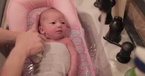 Close Up Baby's First Bath in Slow Motion Stock Footage 104875580
