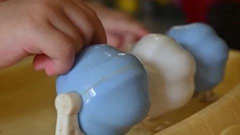 Close up of a baby's hand spinning a ringing ball Video stock 256185177
