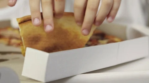 Close-up of baby's hand taking a piece of juicy, greasy pizza and bringing it to Stock Footage 103651405