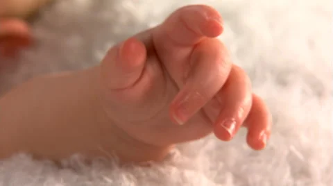 Close-up of a baby's tiny hand, left pan to baby's face 스톡 동영상 59537727