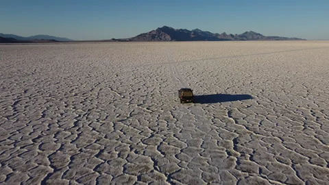 Close back aerial view of chasing truck driving on Bonneville salt flats at.. Stock Footage 276422377