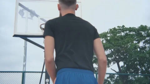Close-up back basketball player throws the ball into the basketball hoop Video stock 236981258