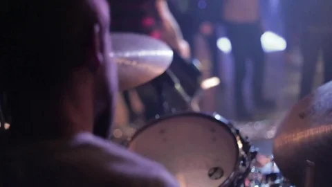 Close-up from back the drummer with view at musicians rock band and fans in blur Stock Footage 82846778