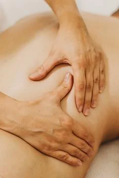 Close up of back massage therapy session. Female massage therapist's hands. Фото