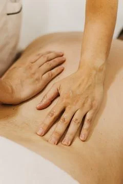 Close up of back massage therapy session. Female massage therapist's hands. Fotos Stock
