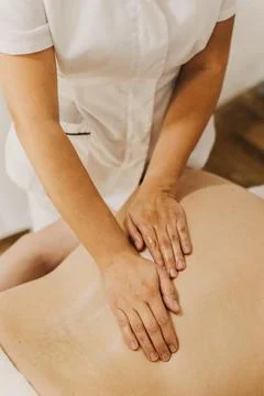 Close up of back massage therapy session. Female massage therapist's hands. Фото