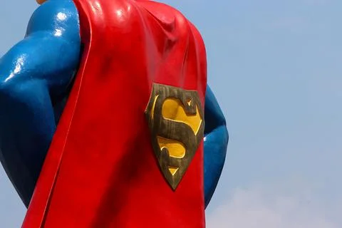 Close up of the back of a metal statue of Superman. The statue has a red ca.. Stock Photos