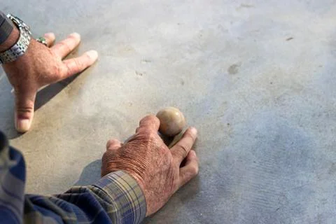 Close-up back shoot of old man plays traditional turkish game on concrete Stock Photos