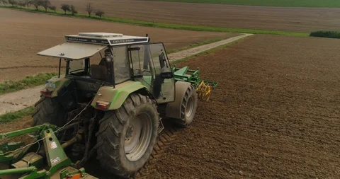 Close-up back view of the agricultural tractor working on the harvest field in Stock Footage 87474521