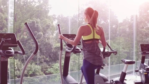 Close up. Back view of attractive young woman working out on an elliptical Stock Footage 85197660