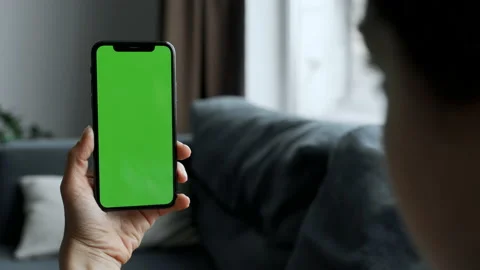 Close up back view of brunette holding chroma key green screen smartphone Stock Footage 155680929