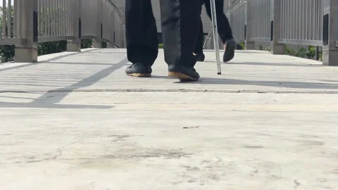 Close-up of back view elderly person shoes and crutch walking Video stock 232561703