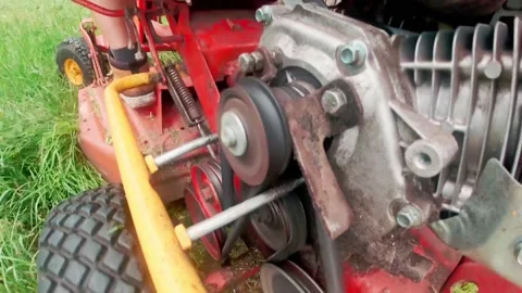 Close up back view grass mower belt spinning. Old lawn mower machine technolo Vidéo 157604106