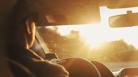 A close back view of a grown-up man in sunglasses driving a car during daytime Stock Footage 96204573