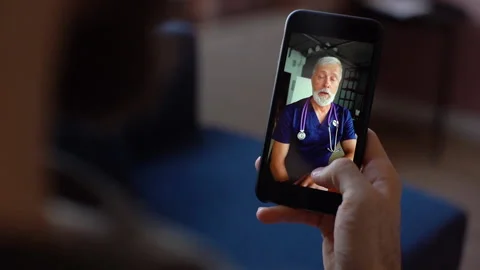 Close-up back view of male chatting via video call with senior doctor on phone Stock Footage 150052486