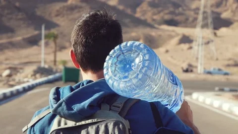 Close-Up Back View Of A Man Carrying A Bottle Of Water On His Shoulder Stock Footage 221618586
