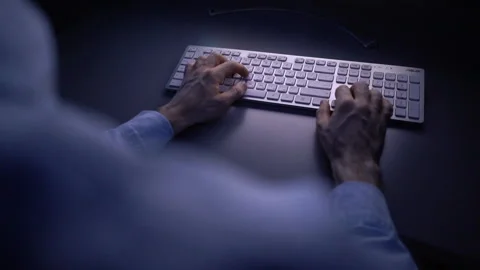 Close-up back view of man watching on monitor and working typing on wireless Stock Footage 146316121