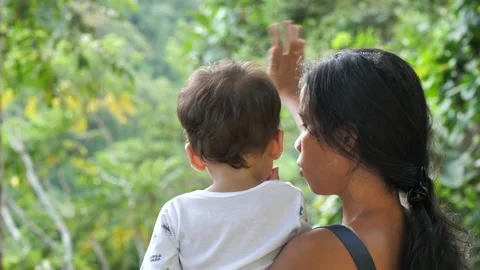 Close up Back view of a mother carrying little a boy in nature background. Stock Footage 223106700