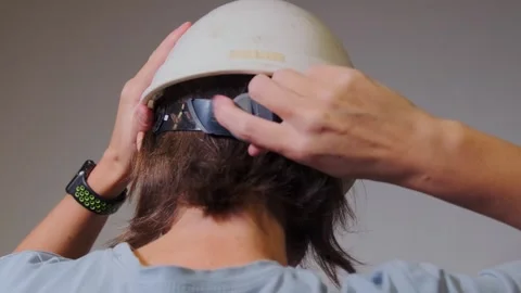 Close-up back view of person adjusting size of white safety helmet using rear Video stock 333580980