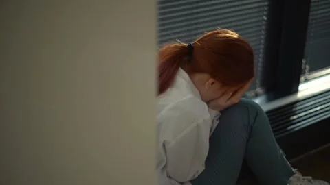 Close-up back view of sad depressed female doctor crying sitting near window Stock Footage 153544173