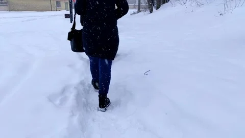 Close-up back view of two female walking in winter snowy city street. Stock Footage 149012122