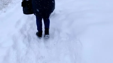 Close-up back view of two female walking in winter snowy city street. Stock Footage 149219302