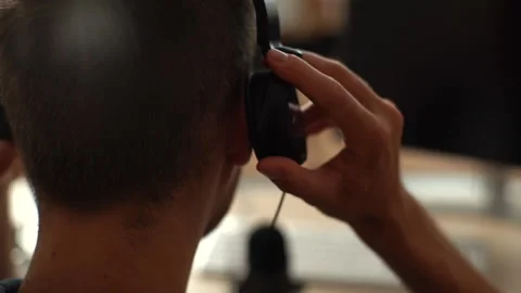 Close-up back view of unrecognizable blogger male putting headphones on head Stock Footage 156899334