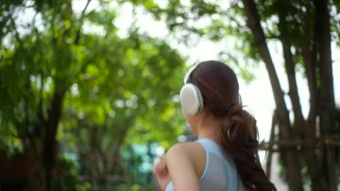 Close up back view of young beautiful asian woman jogging outdoor at village par Stock Footage 282422425