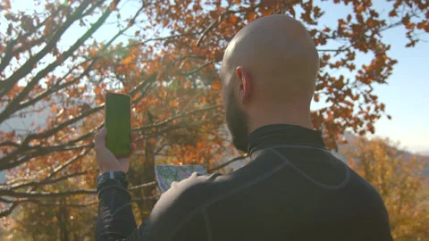 Close-up back view of young man holding mobile phone with green screen clicking Stock Footage 166158713