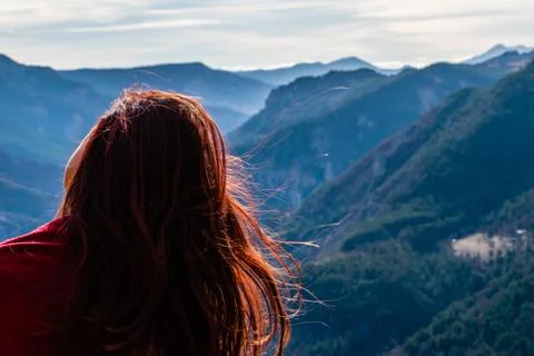 A close-up back view of a young redhead woman with her head tilted and long h Stock Photos
