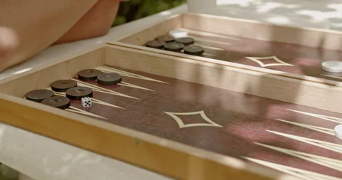 Close-up of a backgammon game being played outdoors between two friends on a Stock Footage 280570984