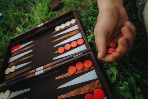 Close-up of backgammon game outdoors with player holding dice Stock Photos