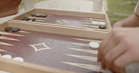 Close-up of a backgammon game in progress. Players are moving black and white Stock Footage 281966227