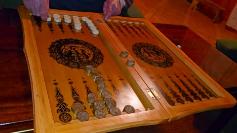 A close-up of a backgammon game in progress shows players moving black and white Stock Footage 301092352