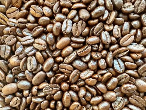 Close up background of coffee beans scattered on surface Stock Photos