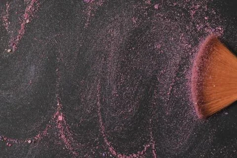 Close up. background image of a brush smears grains of powder on a black Stock Photos