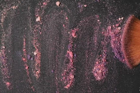 Close up. background image of a brush smears grains of powder on a black Stock Photos