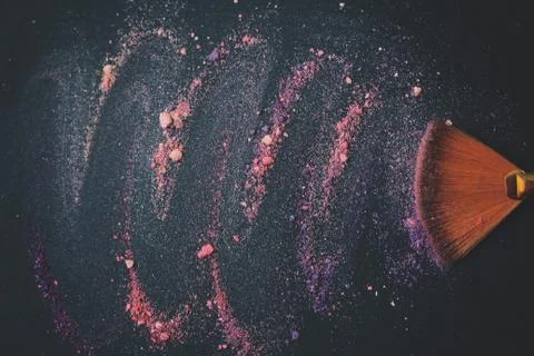 Close up. background image of a brush smears grains of powder on a black Stock Photos