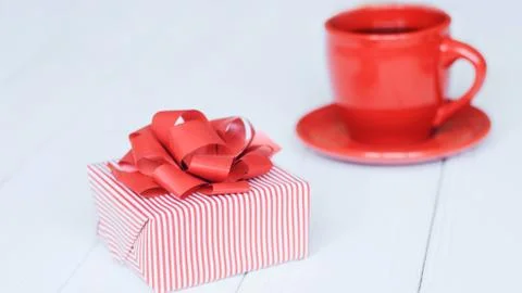Close-up background image of red Cup and gift box on light background. Stock Photos