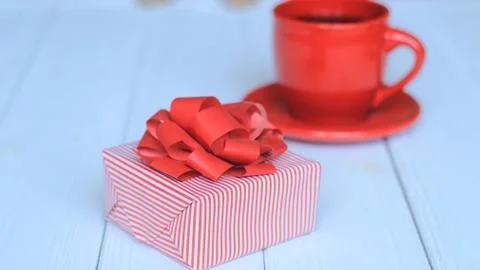 Close-up background image of red Cup and gift box on light background. Stock Photos