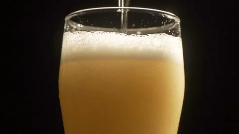Close up background of pouring beer with bubbles and foam in glass Stock Footage 104849241